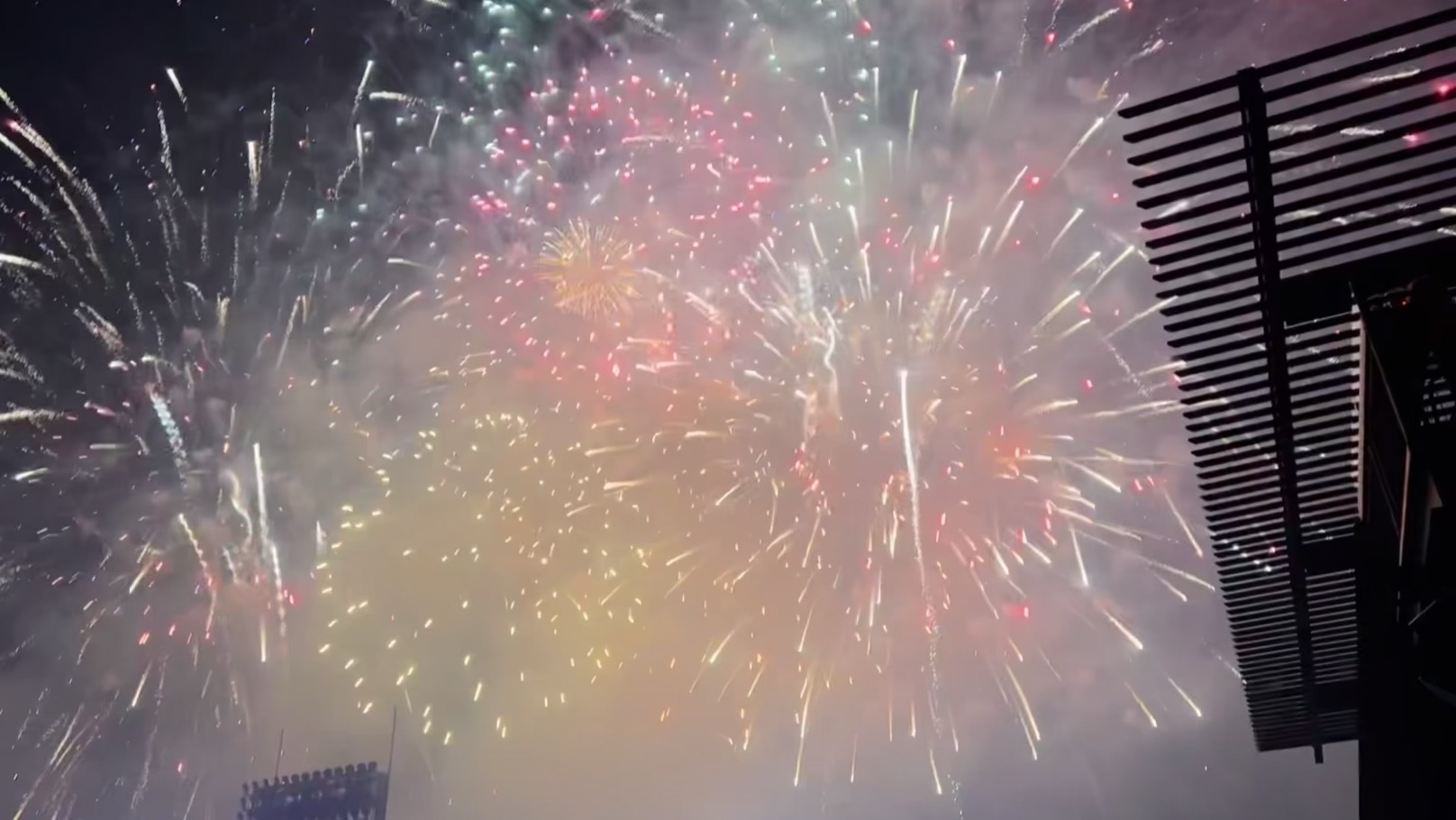 A sky filled with red, white, and gold fireworks